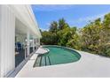 Backyard oasis with a refreshing pool, covered patio, and lush greenery for ultimate relaxation and privacy at 6203 11Th W Ave, Bradenton, FL 34209