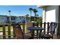 Relaxing balcony with a table and chairs, overlooking lush greenery and nearby buildings at 6300 Flotilla Dr # 108, Holmes Beach, FL 34217