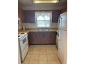 Traditional kitchen with brown wood cabinets, double basin sink and white appliances at 6300 Flotilla Dr # 108, Holmes Beach, FL 34217