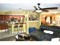 Inviting living space open to kitchen, featuring a comfortable sofa, ceiling fan, and breakfast bar with seating at 6704 Rosemary Dr, Tampa, FL 33625