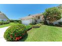 Charming home with well-manicured lawn, colorful bushes, and attached two-car garage, reflecting curb appeal at 7023 Woodside Oaks Cir # 1, Sarasota, FL 34231
