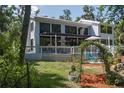 Expansive backyard with patio, a well-maintained garden, mature trees, and a seating area connected to a modern home at 7251 Fish Farm Rd, Palmetto, FL 34221