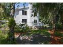 View of backyard featuring a lush, landscaped garden with mature trees, fencing, and a deck area accessible from the home at 7251 Fish Farm Rd, Palmetto, FL 34221