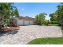 Spacious three-car garage with ample driveway parking and mature landscaping at 7321 Hemlock Ln, Sarasota, FL 34241