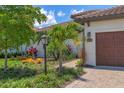Close up of the exterior, highlighting the well-kept landscaping and paver walkway leading to the front door at 8020 Clearwater Ct, Sarasota, FL 34241