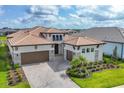 Elegant home featuring a well-manicured lawn, paver driveway, and a three-car garage at 8962 Baroque Ter, Sarasota, FL 34240