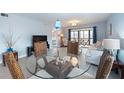 Open-concept dining area with glass table, wicker chairs, and view of the living space at 110 Vista Hermosa Cir # 302B, Sarasota, FL 34242