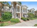 Beautiful townhouse exterior featuring a balcony, manicured landscaping, and Mediterranean architectural style at 1519 Napoli E Dr, Sarasota, FL 34232