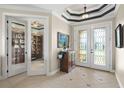 Welcoming foyer with tile flooring, decorative ceiling, and glass doors leading to office and outdoor views at 1736 Suzi St, Punta Gorda, FL 33950