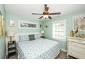 Bright bedroom with a patterned blue and white comforter, white wainscoting and tropical decor at 211 65Th St, Holmes Beach, FL 34217