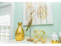 Close up of tropical decor featuring golden vase, wooden heron statue and golden pineapple artwork at 211 65Th St, Holmes Beach, FL 34217