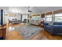 An open-concept living room with hardwood floors, a ceiling fan, lots of natural light, and comfortable furnishings at 221 85Th St, Holmes Beach, FL 34217
