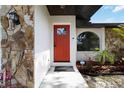 Close up of the front door with stone details, showing Ring doorbell and manicured landscape at 2477 Wood Oak Dr, Sarasota, FL 34232