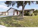 Single-story house showing garage, front door, front lawn, and landscaping at 2477 Wood Oak Dr, Sarasota, FL 34232