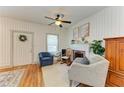 Cozy living room featuring a decorative fireplace, ceiling fan, wood floors and comfortable seating at 2509 8Th W Ave, Bradenton, FL 34205