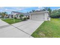 The property features a long concrete driveway leading to an attached two-car garage and a landscaped front yard at 3162 27Th E Ct, Palmetto, FL 34221