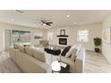 Bright and airy living room featuring neutral tones, modern fireplace, and backyard pool views at 3808 Cape Vista Dr, Bradenton, FL 34209