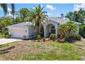 Charming single-story home with a two-car garage, lush landscaping, and a well-maintained front yard at 3988 Berlin Dr, Sarasota, FL 34233