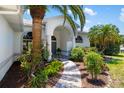 Inviting front entrance featuring arched entryways, elegant landscaping, and a winding walkway at 3988 Berlin Dr, Sarasota, FL 34233