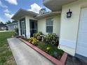 A close-up of a well manicured front yard with a decorative garden and stone birdbath at 4027 Allure Ln, North Port, FL 34287