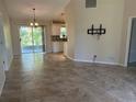 Bright living room featuring neutral tile floors, sliding glass doors and seamless access to kitchen at 4027 Allure Ln, North Port, FL 34287