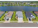 Aerial view of a blue single Gathering home on a lake, featuring well-manicured lawns at 4407 Big Woods Way, Parrish, FL 34219