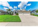 Inviting single-story home with lush green lawn, garden beds, and spacious driveway at 5319 120Th E Ave, Parrish, FL 34219