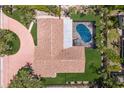 Aerial shot of a beautiful home with a private pool, lush landscaping, and a brick driveway at 5581 Shadow Lawn Dr, Sarasota, FL 34242