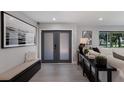 Bright foyer area featuring gray double doors, tile floors, and contemporary decorations at 5581 Shadow Lawn Dr, Sarasota, FL 34242
