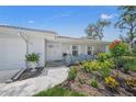 Charming home featuring a welcoming front porch and colorful landscaping at 572 Commonwealth Ln, Sarasota, FL 34242
