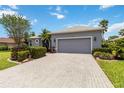 Long driveway leads up to a two-car garage, complimented by manicured landscaping and beautiful blue skies at 664 Planters Manor Way, Bradenton, FL 34212