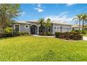 Charming one-story home with an arched entrance, manicured landscaping, and a well-maintained front lawn at 664 Planters Manor Way, Bradenton, FL 34212