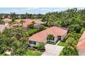 Expansive aerial view showcasing the red tile roof, mature landscaping, and well-maintained grounds at 706 Misty Pond Ct, Bradenton, FL 34212