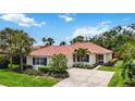 Charming single-story home with a tile roof, beautiful landscaping, and a spacious concrete driveway at 706 Misty Pond Ct, Bradenton, FL 34212