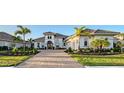 Elegant home featuring lush landscaping, a brick driveway, and a well-manicured lawn at 7838 Bowspirit Way, Lakewood Ranch, FL 34202