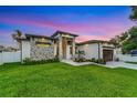 Gorgeous modern home showcasing stone accents, professional landscaping, and a freshly sealed driveway at 805 Padua Ct, Nokomis, FL 34275