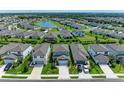 An aerial view of a neighborhood with a pond with well-maintained lawns and landscaping at 8940 Royal River Cir, Parrish, FL 34219