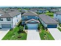 Aerial view of a well-maintained two-story home with lush landscaping and a two-car garage at 8940 Royal River Cir, Parrish, FL 34219