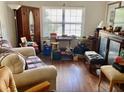 Inviting living room with hardwood floors and a vintage armoire and window at 104 22Nd Street E Ct, Bradenton, FL 34208