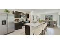Modern kitchen featuring stainless steel appliances, center island with seating and dark wood cabinetry at 10821 Gentle Current Way, Parrish, FL 34219
