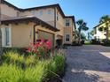 Attractive two-story condo featuring a brick driveway, tropical landscaping, and an attached garage at 1241 Riverscape St # B, Bradenton, FL 34208