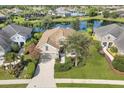 Breathtaking aerial view of a well-maintained home with lush landscaping and a serene pond backdrop at 12908 Crystal Clear Pl, Bradenton, FL 34211