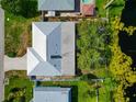 Aerial view of a home with a light grey metal roof and lush green surroundings near a lake at 1312 73Rd Nw St, Bradenton, FL 34209