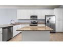 Well-lit kitchen with granite countertops, stainless steel appliances, and tile flooring at 17118 Vardon Ter # 404, Bradenton, FL 34211