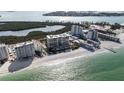 Stunning aerial view of beachfront condos with lush greenery and sparkling ocean at 1800 Benjamin Franklin Dr # B1009, Sarasota, FL 34236