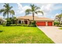 Attractive single-story home featuring a well-manicured lawn, palm trees, and a three-car garage at 312 148Th Ne Ct, Bradenton, FL 34212