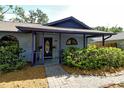 Charming home with a covered front entrance, lovely landscaping, and a decorative front door at 4137 Woodview Dr, Sarasota, FL 34232