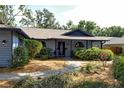 Charming home with a beautiful front garden, a brick walkway, a covered entry, and attractive blue and gray accents at 4137 Woodview Dr, Sarasota, FL 34232