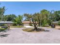 View of the home situated on a quiet cul-de-sac, surrounded by mature trees and landscaping at 435 Whispering Oaks Ct, Sarasota, FL 34232
