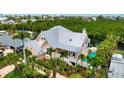 Aerial view of a charming home with a metal roof, pool, and lush tropical landscaping and a bayou in the background at 512 77Th St, Holmes Beach, FL 34217